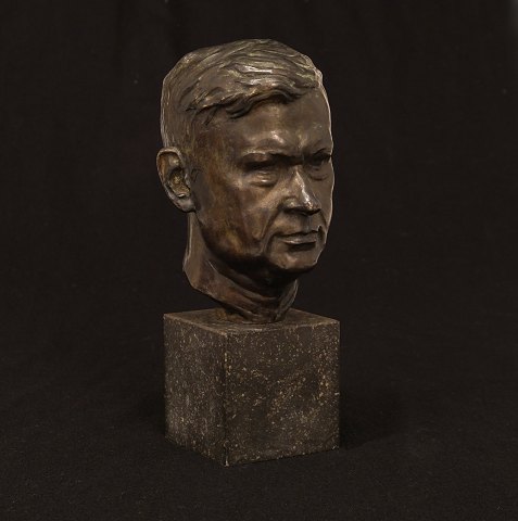 Bronzehoved på stensokkel. Støbt af L. Rasmussen, København, der bl.a. udførte opgaver for Kai Nielsen. H: 25,7cm