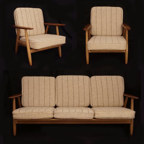 Hans J. Wegner, 1914-2007: "Cigarren". Møbelsæt bestående af to armstole og en sofa. Massivt stel i eg og armlæn i teak. GE 240. Designet af Wegner 1955