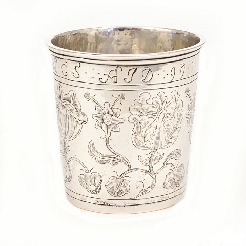 Sølvbæger. Lille kraftigt sølvbæger prydet med stiliserede blomster og navnetræk med datering 1699. Danmark. Sandsynligvis bryllupsbæger. H: 7,1cm. V: 103gr