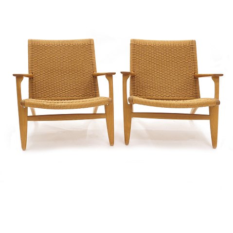 Hans J. Wegner: Ein Paar CH 25 Stühle aus Eiche. 
Sehr schön patiniert in einem sehr gutem Zustand. 
Beide mit Aufklebern vom Produzenten Carl Hansen & 
Søn. H: 71cm. B: 70cm