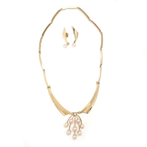 Just Andersen smykkesæt i 14kt guld bestående af leddelt halskæde med perlevedhæng og et par perleøreringe. Stemplet "Just A 585". Halskæde længde: 41cm. V: 35,1gr