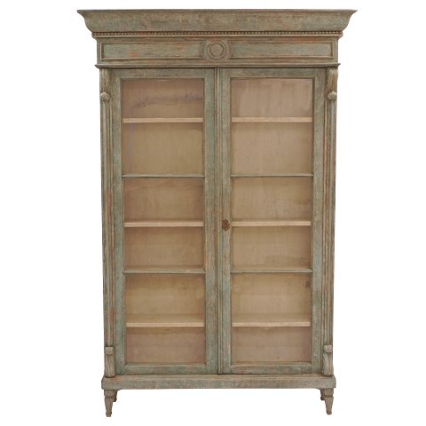 Lys grågrøn vitrine med to døre og fem hylder. Ca. 
år 1850. H: 213cm. B: 139cm. D: 36cm (top) / 25cm 
(midt)