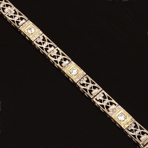 14kt hvidguld leddelt armlænke prydet med 
gennembrudte dekorationer og tre diamanter ca. 
0,25ct i alt. L: 18,5cm. B: 4,5mm