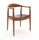 Hans J. Wegner, 1914-2007: The Chair i teak. Rygstykke med repareret brud. Se venligst foto. Stolen fremstår ellers stabil og brugbar. Sæde med sort læder
