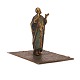 Figur forestillende orientalsk mand på tæppe i formessinget tin og dekoreret. H: 
9,5cm. Base: 9x11cm