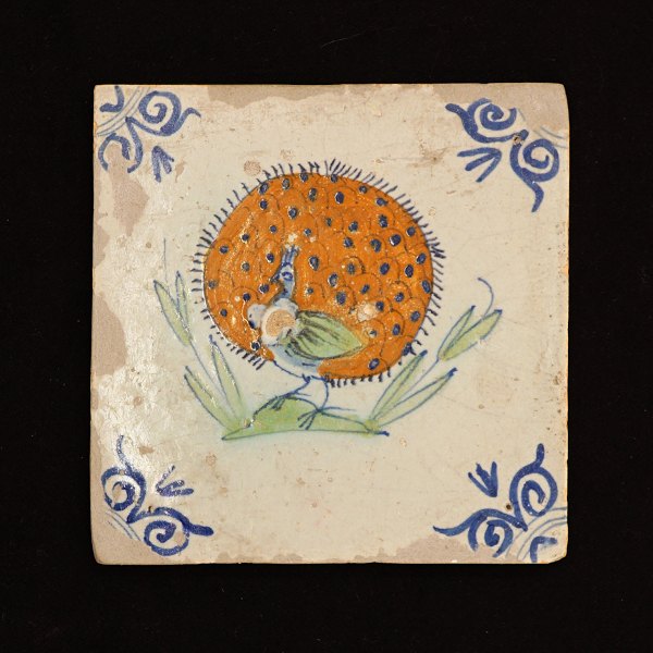 Polykromdekoreret flise med motiv i form af påfugl. Holland ca. år 1620. 13x13cm