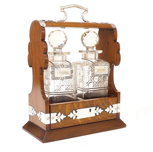 Tantalus i egetræskasse med to karafler til hhv. cognac og whisky. Nøgle medfølger. England ca. år 1880. H: 33cm. B: 25cm. D: 14cm