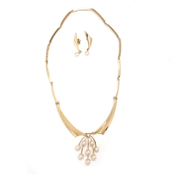 Just Andersen smykkesæt i 14kt guld bestående af leddelt halskæde med perlevedhæng og et par perleøreringe. Stemplet "Just A 585". Halskæde længde: 41cm. V: 35,1gr